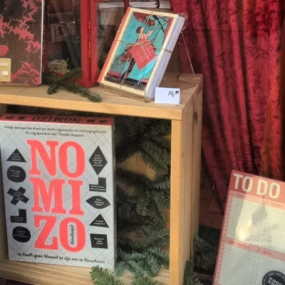 Nomizo in de etalage van Boekhandel Den Boer in Baarn